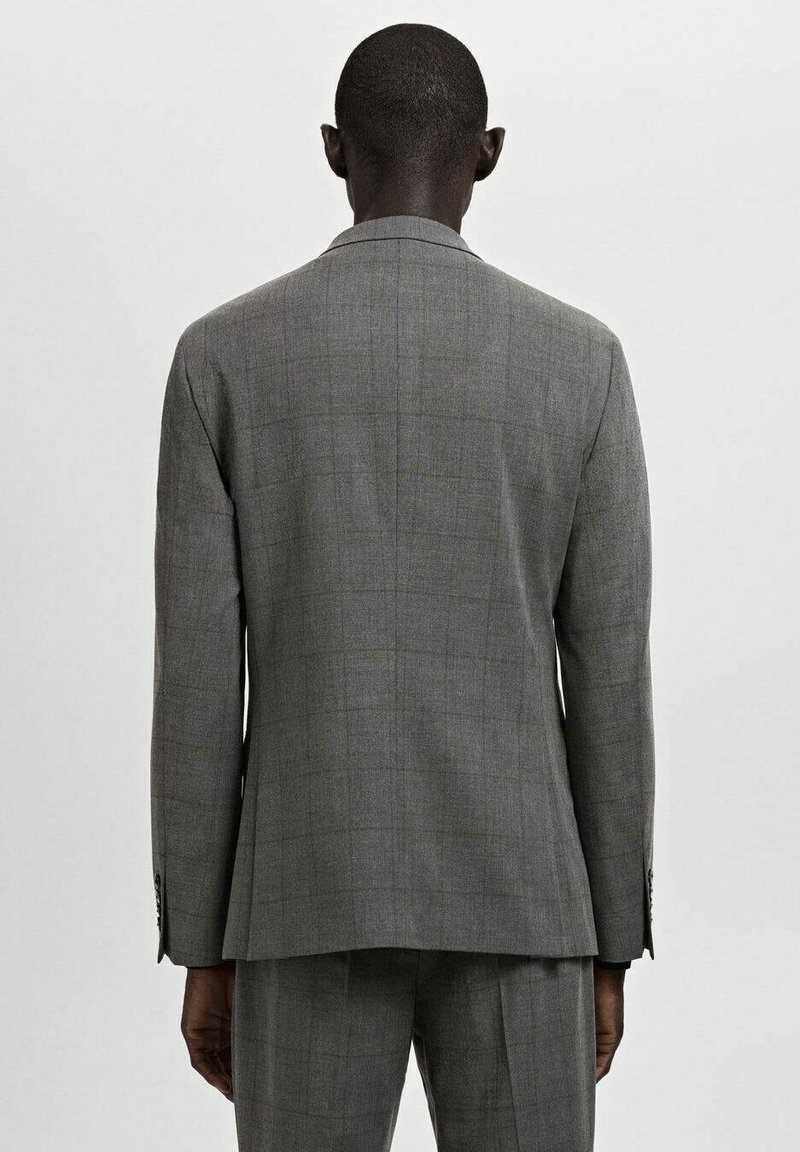 Grauer Karoanzug mit einem maßgeschneiderten Blazer, der einen einzigen Schlitz, lange Ärmel und sichtbare Knöpfe an den Manschetten hat.