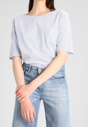 Biała koszulka z granatowymi poziomymi paskami, krótki rękaw i kieszonka. W zestawieniu z jasnoniebieskimi spodniami o wysokim stanie. Casualowy fason.