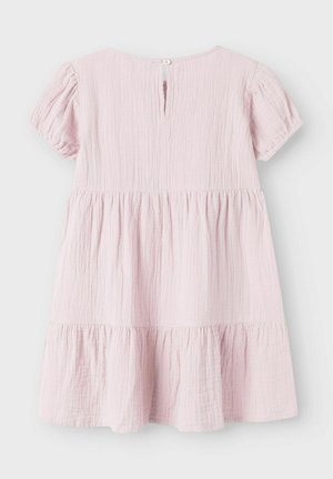 Rosa bomullskjole med korte puffermer, teksturert stoff, rund hals og knappelukking i ryggen. Har en lagdelt volangkant.