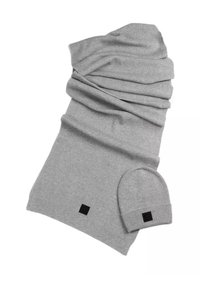 Grijze geribbelde gebreide sjaal met bijpassende beanie; heeft een gestructureerde afwerking en een klein zwart labeldetail op beide items.