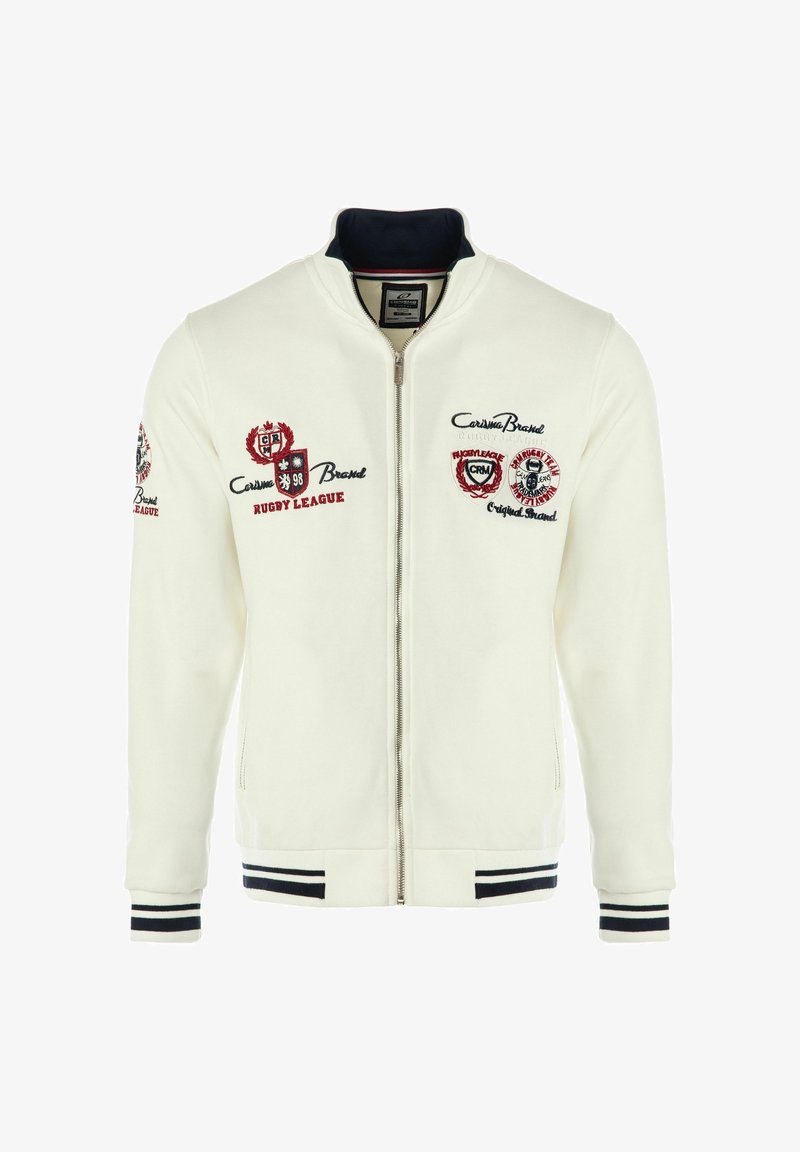 Bela zip-up jakna z vezenimi logotipi v rdeči in črni barvi. Žameten rob in hem z črnimi in belimi črtami. Gladka tekstura tkanine.