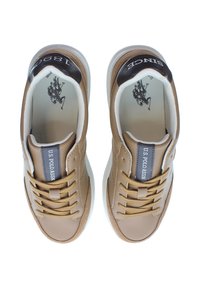 Pár béžových tenisek U.S. Polo Assn. s hnědými tkaničkami, bílými podrážkami a černými akcenty na patách s nápisy "1980" a "SINCE," z pohledu shora.