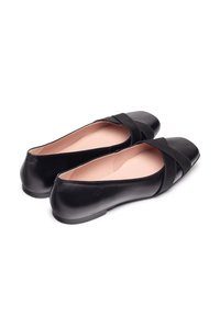 Ballet flat in pelle nera con finitura liscia, dotate di un dettaglio incrociato sulla parte superiore e una punta arrotondata. Interno morbido in beige.