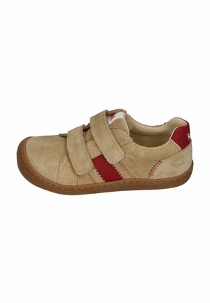 Beige suede sneaker with double Velcro straps, red side stripes, a brown rubber sole, and red heel patch with white logo.