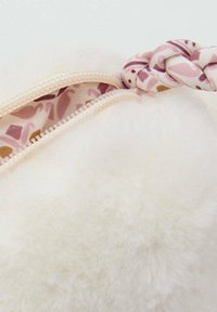 Bela umetna krznena torba z zadrgo. Notranjost ima rožnato vzorčasto podlogo in pleteno tekstilno ročico. Satenast občutek.