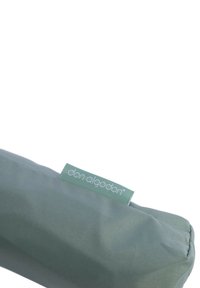 Accesorio de tela verde con una textura suave, que presenta una etiqueta verde clara con "don algodon" en texto blanco. Forma redondeada, diseño sencillo.