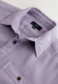 Hele lilla pikkade varrukatega särk terava kraega, millel on üks rinnatasku ja pruunide nuppudega detailid. Kangas tundub tekstuuriga.