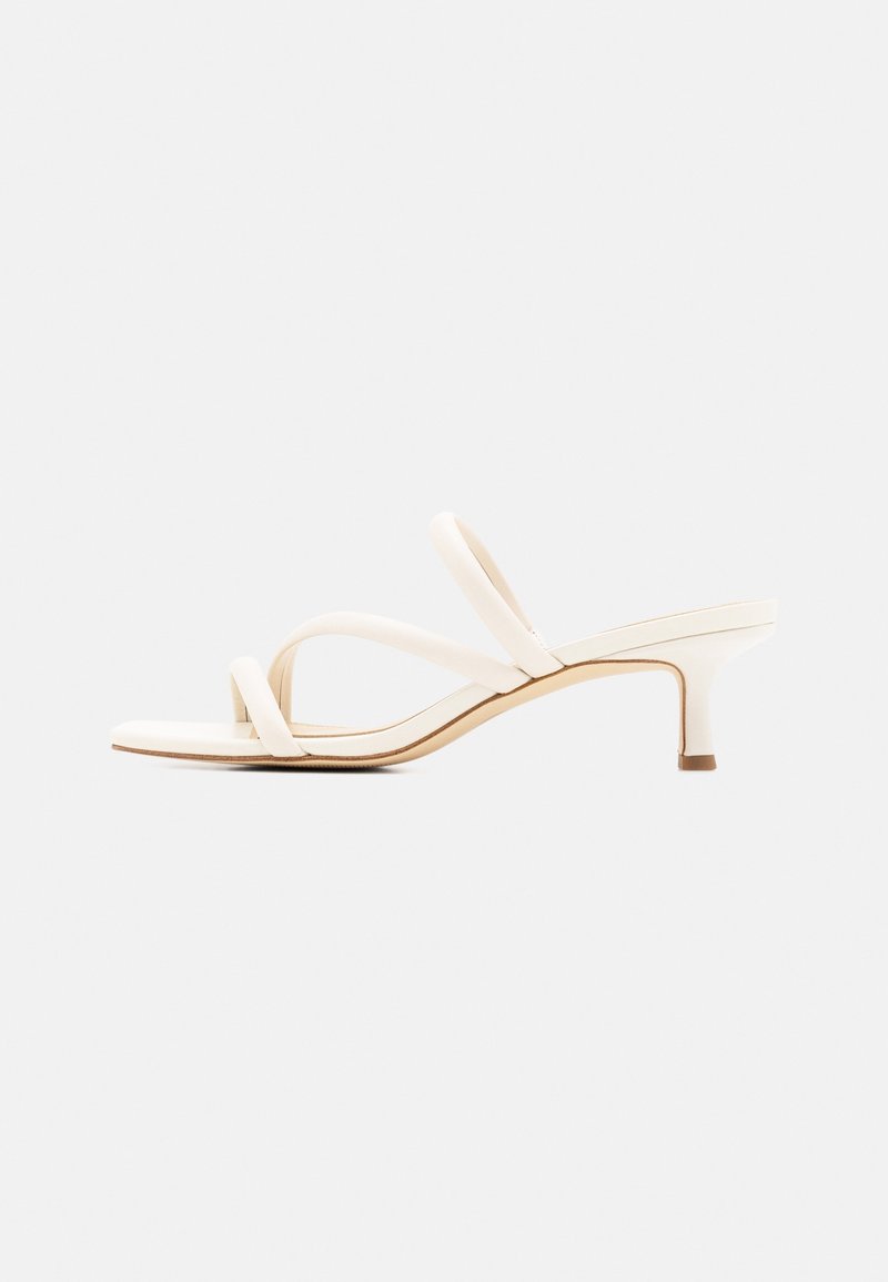 Sandale blanche pour femme à talon bas, bout carré et trois fines lanières sur le pied et le talon.