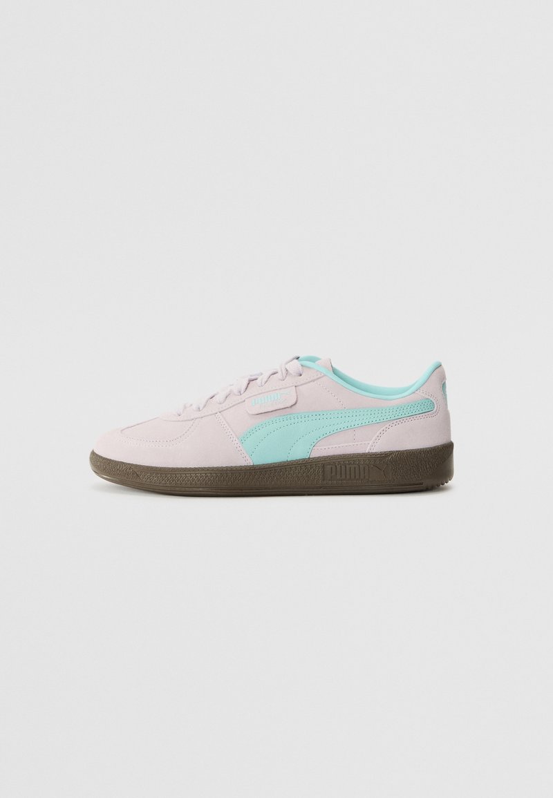 Light pink suede sneakers with turquoise accents, white laces, and a brown rubber sole featuring a textured pattern and brand logo.