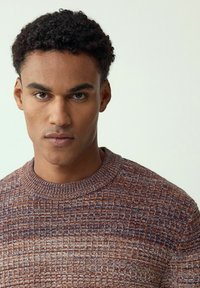 Sweter dziergany z teksturowanym wzorem w ciepłych odcieniach brązu, pomarańczy i niebieskiego, z prążkowanym, okrągłym dekoltem oraz dopasowanym krojem.