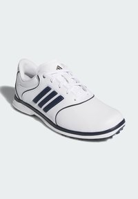 Chaussures de golf blanches en matériau synthétique, dotées de trois bandes bleu marine, d'un design épuré, d'un laçage avant et d'une semelle en caoutchouc texturée.