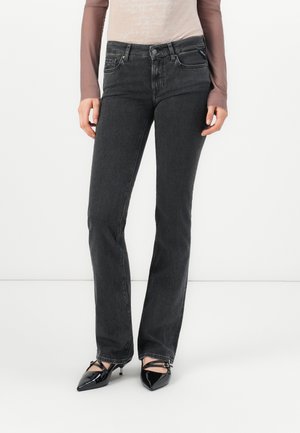 Sorte denim jeans med en tettsittende midje, rett ben-design, subtil tekstur og klassisk fem-lomme stil, kombinert med spisse sorte hæler.