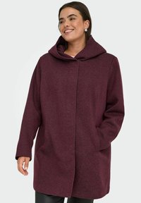 Bordová vlněná bunda kombinovaná s jinými materiály, s velkou kapucí, předními kapsami a rovnou siluetou, s texturovanou tkaninou a zapínáním na knoflíky.