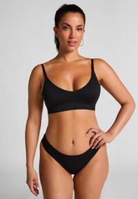 Ensemble de bikini noir comprenant un haut bralette élégant avec des bretelles réglables et un bas taille basse, fabriqué en tissu lisse et extensible.
