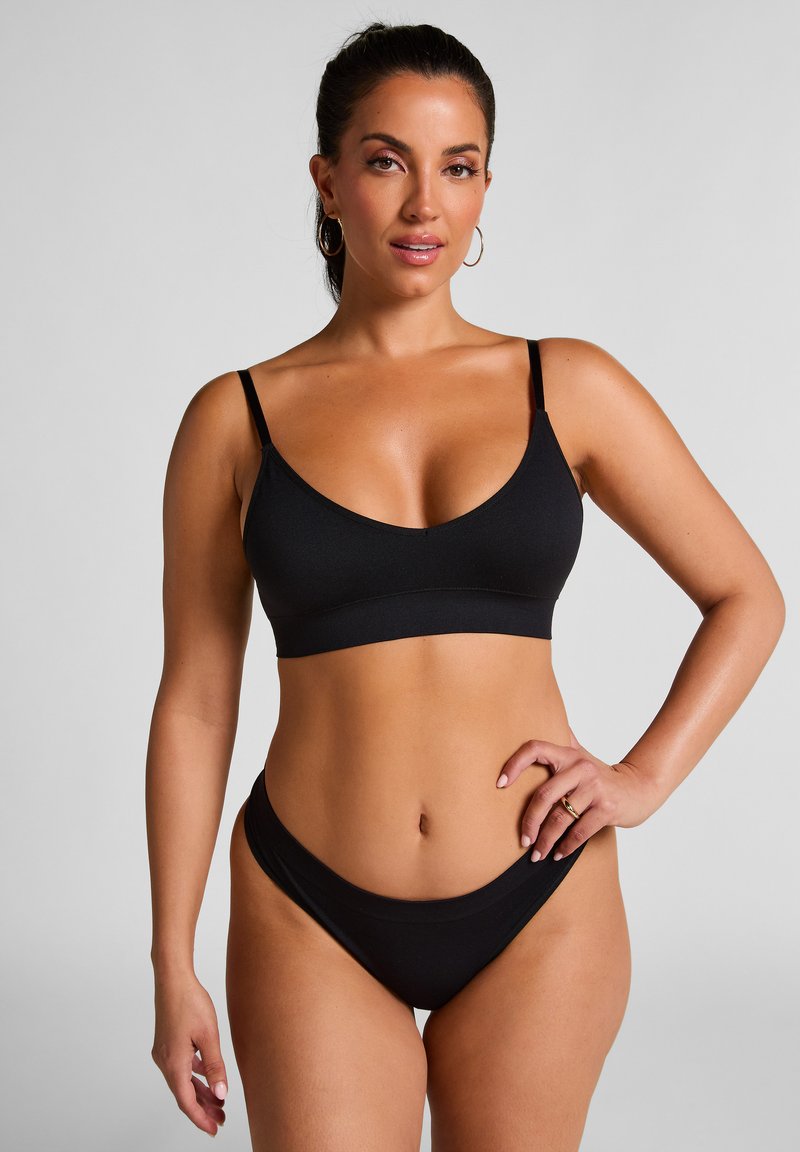 Schwarzes Bikini-Set mit einem eleganten Bralette-Oberteil mit verstellbaren Trägern und tief sitzenden Bottoms, gefertigt aus glattem, dehnbarem Material.