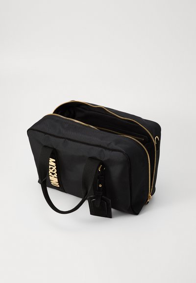 Sac noir en nylon avec fermetures éclair dorées et un logo bien en vue. Il possède deux poignées, une forme rectangulaire et un détail de tag texturé.