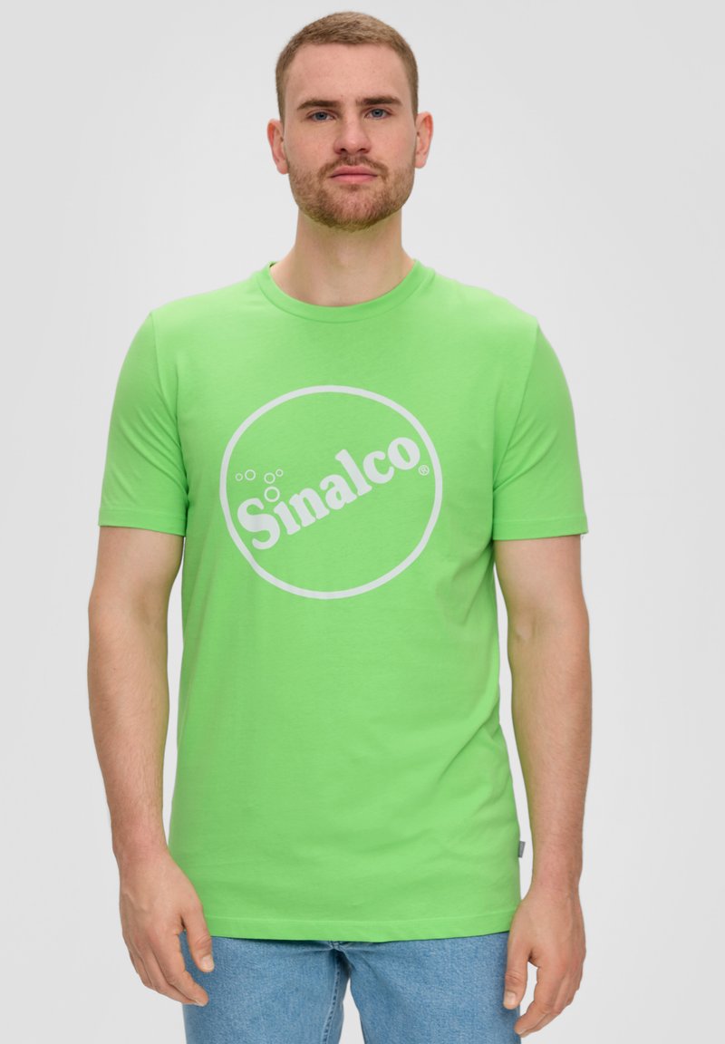 Groene katoenen t-shirt met een ronde hals en korte mouwen. Bevat een wit circulair logo met de tekst "Sinalco" in het midden.