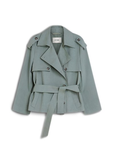 Ανοιχτοπράσινο trench coat με ζώνη, φαρδιές πέτο, κουμπωτούς ιμάντες ώμων και λεπτομέρειες με εμπρόσθιες πτυχώσεις σε λευκό φόντο.