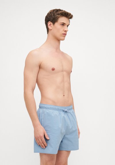 Shorts de bain bleu clair en matériau lisse et léger, dotés d'une taille élastique avec cordon de serrage et sans motifs visibles.