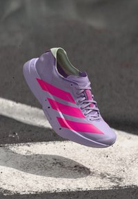 Lila Sportschuh mit pinken Akzenten und Design in drei Streifen. Leicht, glatte Textur und ein gepolsterter Schuhkragen für Komfort.