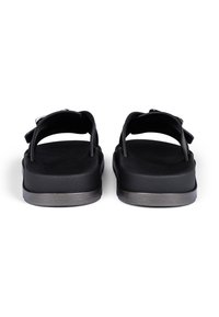 Black sandals with a wide strap design, featuring a padded footbed, adjustable buckle, and a subtle metallic accent on the sole.
