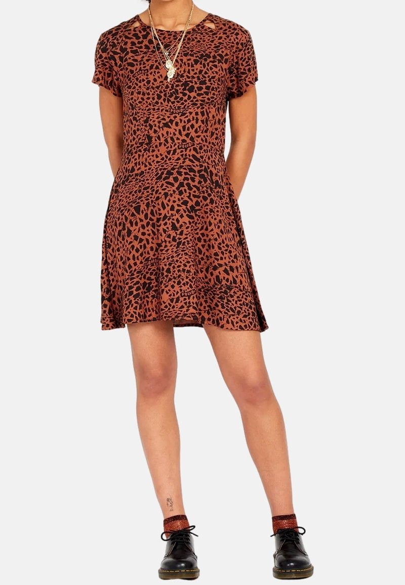 Robe à manches courtes couleur rouille avec imprimé léopard noir, présentant une coupe décontractée, un col arrondi et une jupe évasée. Stylée avec des chaussures noires.