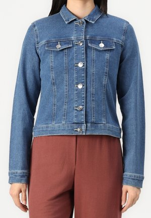 Blue denim jacket with silver buttons, buttoned front, chest flap pockets, long sleeves, worn over rust-colored pants.