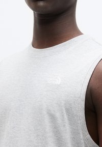 Ανοιχτό γκρι αμάνικη μπλούζα από βαμβάκι, με ένα μικρό λευκό λογότυπο της "The North Face" στην αριστερή πλευρά του στήθους.