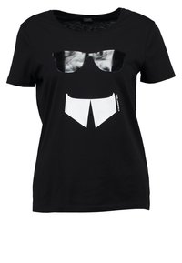 Camiseta negra de manga corta con un estampado de gafas de sol negras brillantes sobre un gráfico de cuello de camisa estilizado en blanco en la parte frontal.