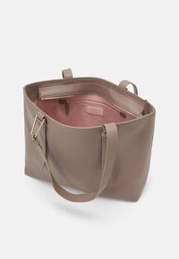 Borsa tote in pelle beige con esterno texturizzato, doppi manici per spalla e un interno rosa liscio con tasca con zip e etichetta del brand.