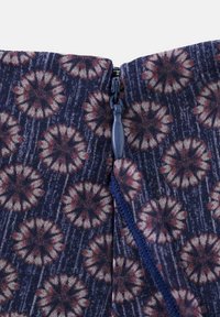 Blue fabric with floral pattern; zip closure at the top; textured finish with floral motifs in red and cream colors.