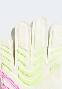 Guanti da portiere con una base bianca e accenti verde brillante e rosa. Le linee di grip testurizzate corrono verticalmente sulle dita.