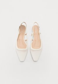 Valkoiset slingback-kengät, joissa on terävä kärki, teksturoitu verkko-osa ja sileä beige sisäpohja. Säädettävä nilkkaremmi lisää tukea.