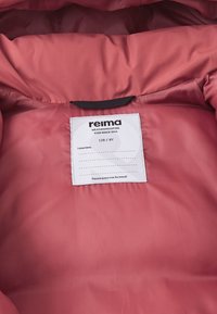 Interno di una giacca isolante rossa con una trama liscia, un'etichetta con informazioni sul marchio e la taglia, e un anello per appenderla.
