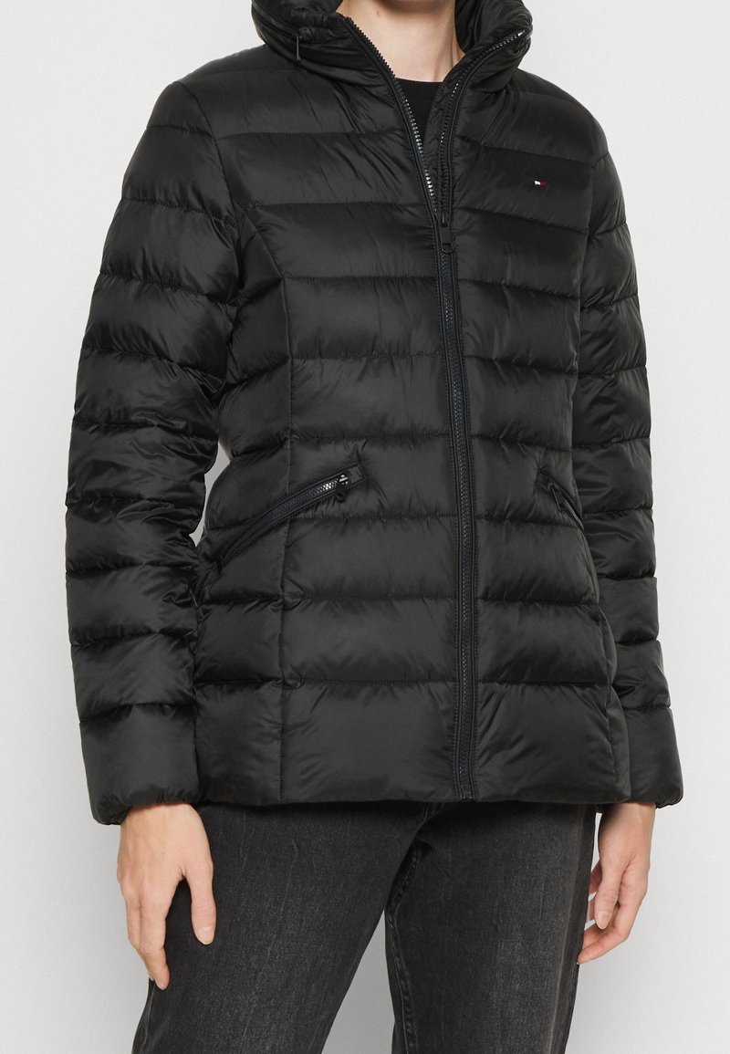 Czarna kurtka puchowa z poziomym pikowaniem, wysoki kołnierz, zamek błyskawiczny oraz boczne kieszenie. Gładki materiał o błyszczącym wykończeniu.