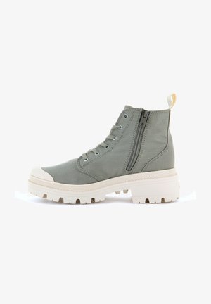 Bottines en toile vert clair avec un bout arrondi, semelle en caoutchouc blanche, zip sur le côté et embout renforcé. Comprend un design à lacets et une languette.