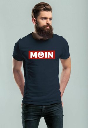 Navyblaue Baumwoll-T-Shirt mit kräftigem roten rechteckigen Grafikdesign, auf dem das Wort "MOIN" und ein Ankersymbol zu sehen sind, Rundhalsausschnitt und kurzen Ärmeln.