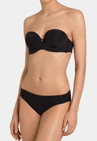 Svart stroppeløs BH med glatt stoff og formede kopper, sammen med matchende lavtlivde bikini-truser med subtil logo-detalj.