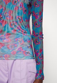 Durchsichtiges Langarmoberteil im mehrfarbigen abstrakten Blumenmuster mit Farbnuancen in Blau, Rosa und Lila; tailliert mit einer glatten Textur.