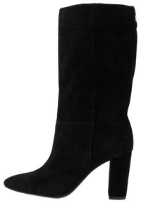 Černé semišové kotníkové boty s špičatou špičkou, vysokým svrškem a robustním podpatkem. Obsahují minimální šití a jemný detail loga.