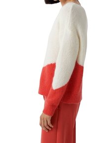 Gebreide trui met een losse pasvorm, met de bovenste helft in het wit en de onderste helft in een levendig rood, gestructureerde stof en geribde mouwen.