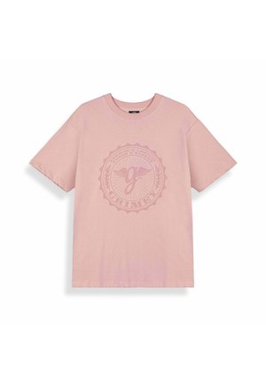 Jasnoróżowa koszulka z krótkim rękawem i okrągłym dekoltem, z wyblakłym okrągłym emblematem z skrzydlatą literą "g" oraz napisem "Grimey" w centrum.