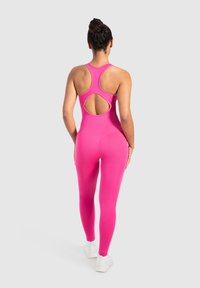 Tight rosa jumpsuit med en unik ryggöppning, tillverkad av elastiskt tyg, med ärmlös design och sömlös konstruktion.