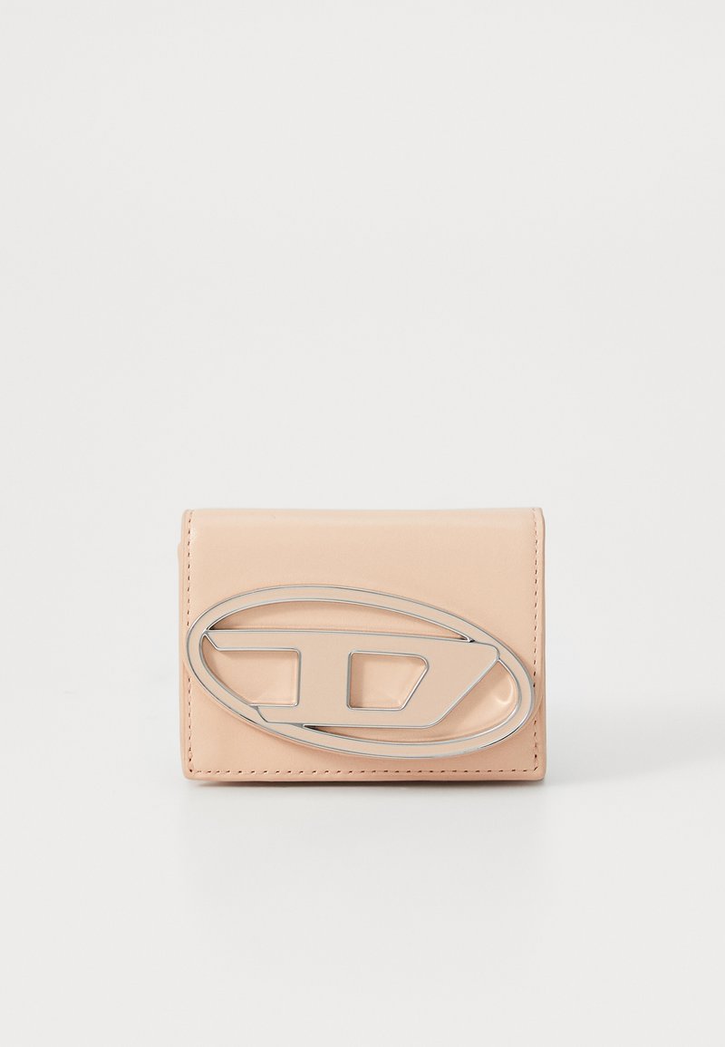 Portafoglio in pelle color pesco con finitura lucida, dotato di un grande accessorio ovale in argento sulla parte anteriore e di una forma rettangolare semplice.