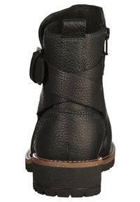 Bottine en cuir noir à surface texturée, avec fermeture éclair latérale et une bride décorative. Elle possède une semelle épaisse en caoutchouc avec une bordure marron.