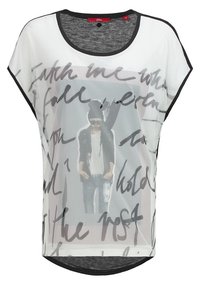 Top blanco semitransparente con acentos negros, escote redondeado y mangas cortas tipo dolman. Presenta una impresión gráfica con texto y la imagen de una modelo.