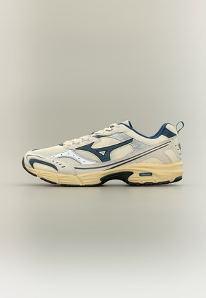 Fehér és tengerészkék atlétikai cipő bézs talppal, hálós felsőrészsel és Mizuno logóval az oldalon, semleges háttér előtt oldalnézetben.