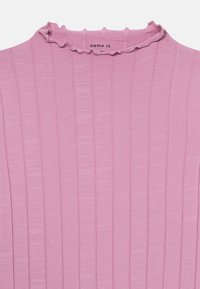 Roze geribde stof top met een kleine ruffled halskraag, die subtiele verticale textuur toont en een gedeeltelijk kledinglabel binnenin.
