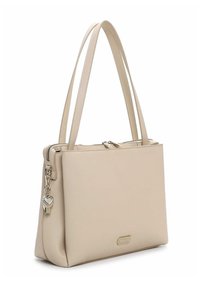 Beige syntetisk håndtaske med et struktureret design, to lange stropper, en lynlåslukning øverst og en hjerteformet vedhæng på siden.