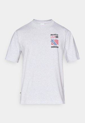 Grijze katoenen t-shirt met korte mouwen, ronde halslijn en een grafische print met "World Cup USA 94" en het Adidas-logo.